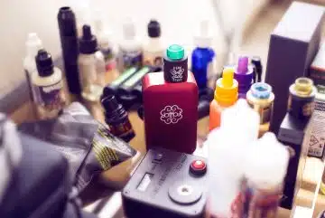 red box mod vape beside e-juice bottles